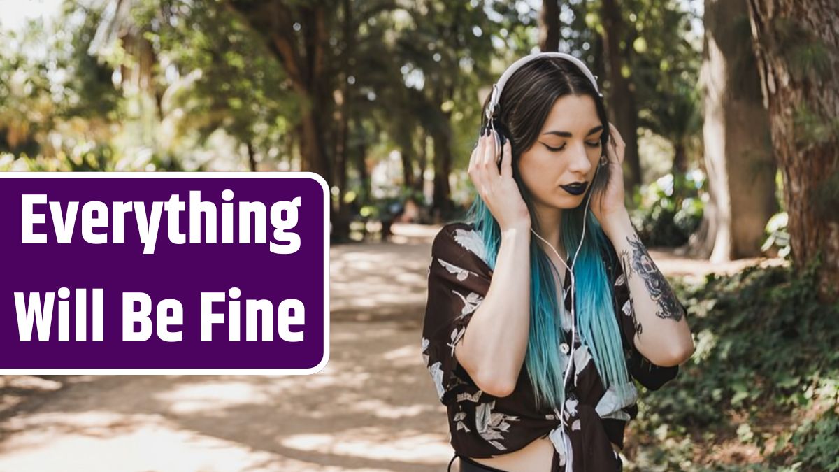 Young woman standing in forest listening music on headphone