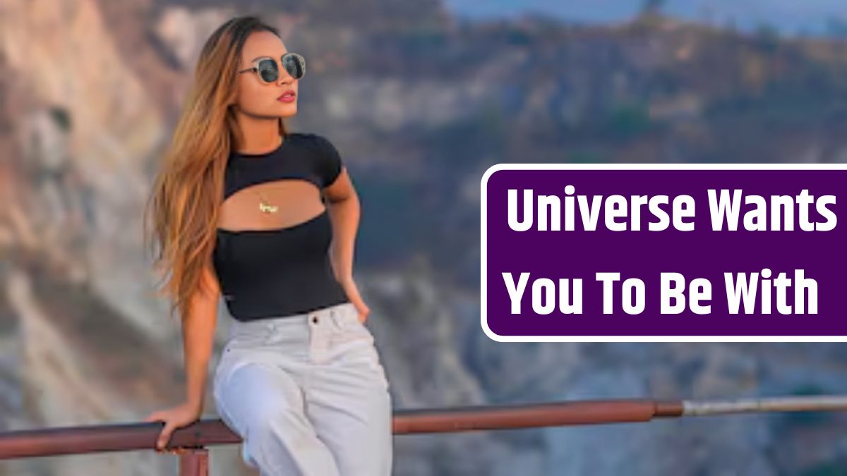 Woman wearing sunglasses standing on railing against mountain