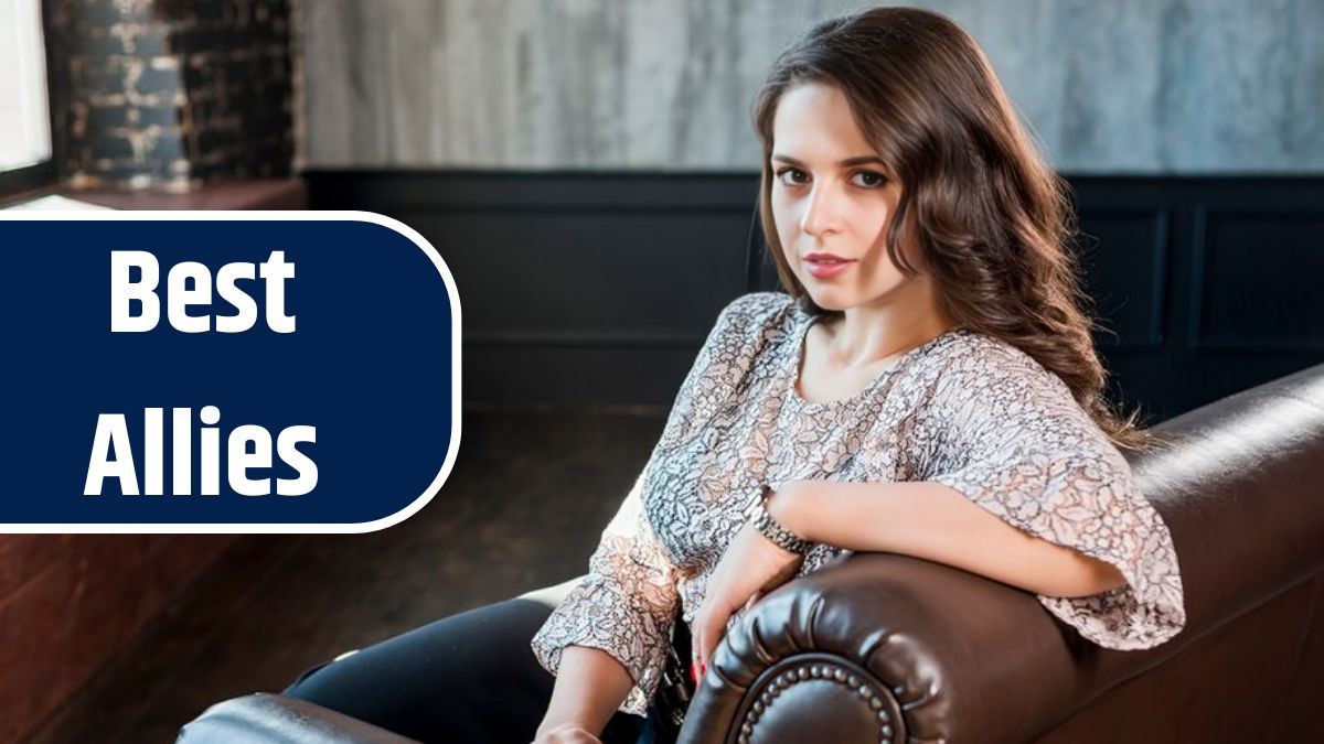 Beautiful young woman sitting on sofa looking at camera